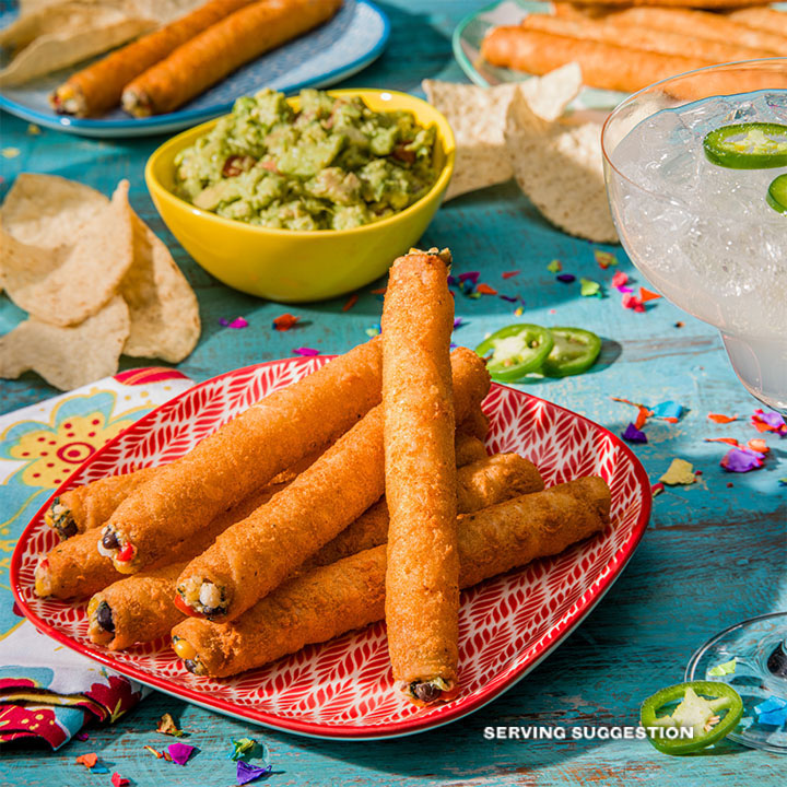 El Monterey Extra Crunchy Southwest Chicken Taquitos served on a plate with a drink and guacamole on the side.