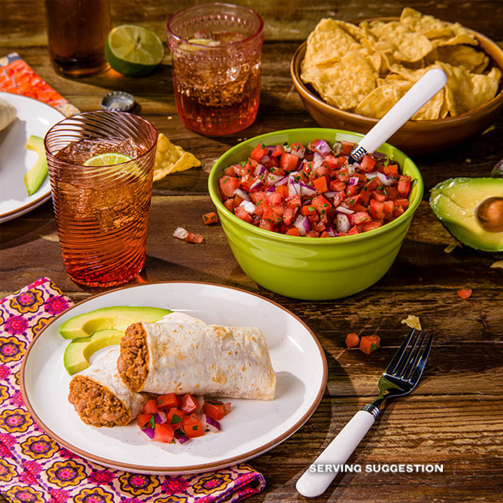 A serving of El Monterey Beef & Bean burritos, served on a table filled with other foods and beverages.